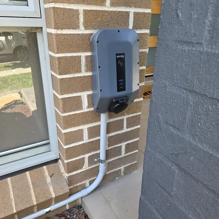 Electrician assessing switchboard for EV charger installation