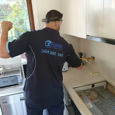 Electrician Using Cable Feeder To Help With Wiring Up An Induction Cooktop