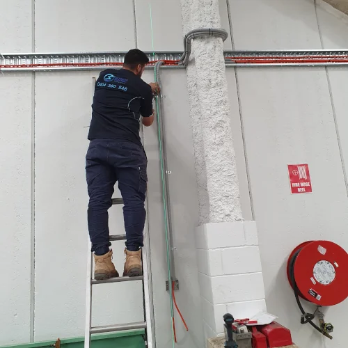 Factory electrician installing 3-phase industrial socket outlet