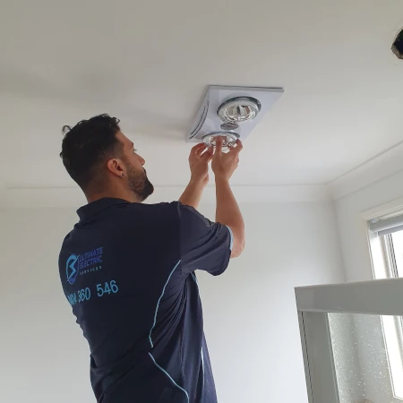 Electrician Installing Heat Lamps Into Bathroom IXL Heater Fixture