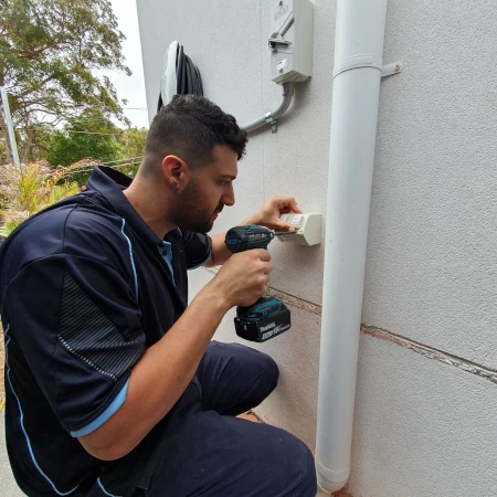 Electrician installing residential outdoor weatherproof power points