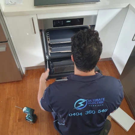 Electrician Finalising Installation Of Electric Oven